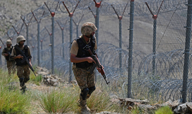 Pakistani soldiers stand guard along the Pakistan-Afghanistan border amid rising cross-border tensions.