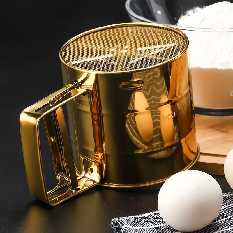 Upgrade your baking with our luxury golden stainless steel flour sifter. Features an easy squeeze handle, ultra-fine mesh, and mess-free cup design. Shop now!